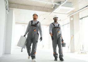 multicultural builders in hardhats at construction site.